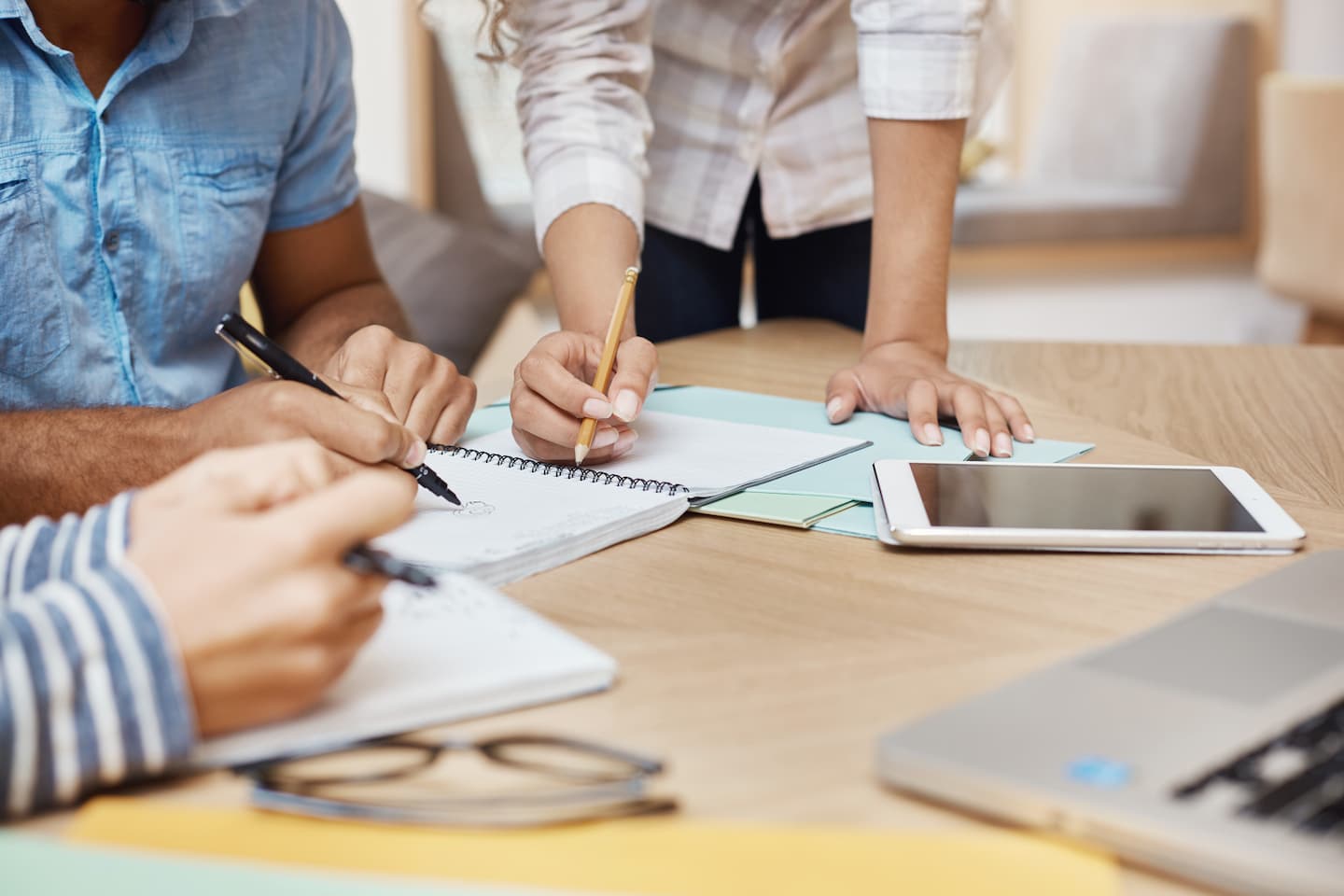 close-up-detail-of-team-working-o-new-project-in-coworking-space-writing-ideas-looking-through-graphics-on-tablet-and-laptop-teamwork-business-concept (1)