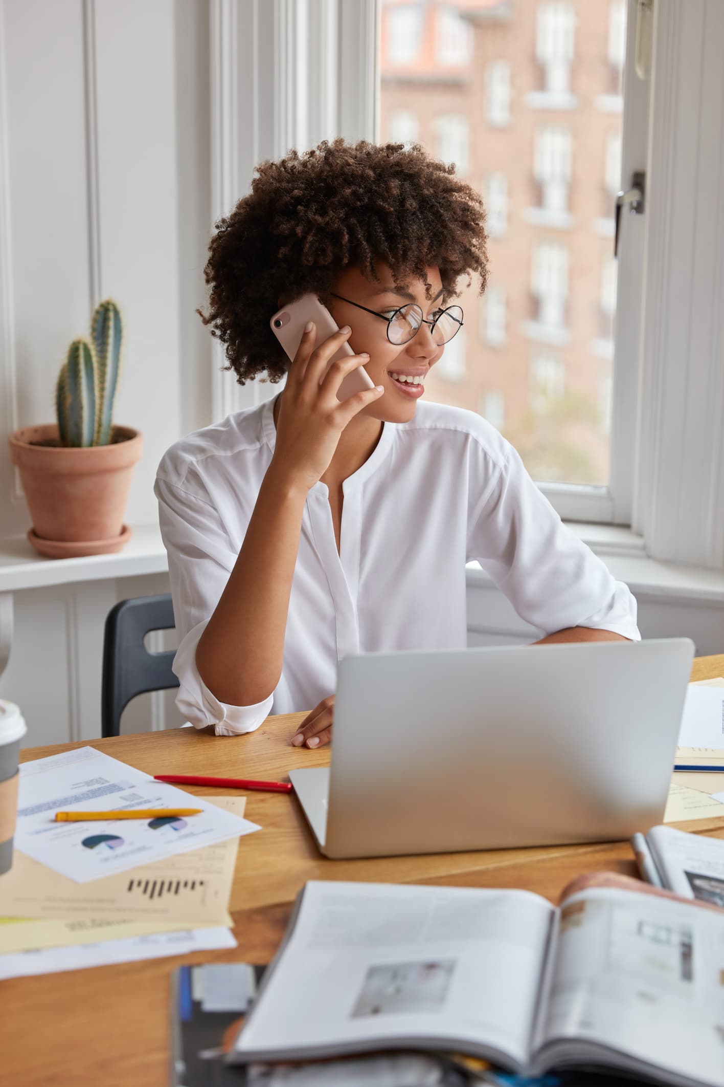 vertical-shot-of-pretty-black-businesswoman-examines-charts-on-papers (1)